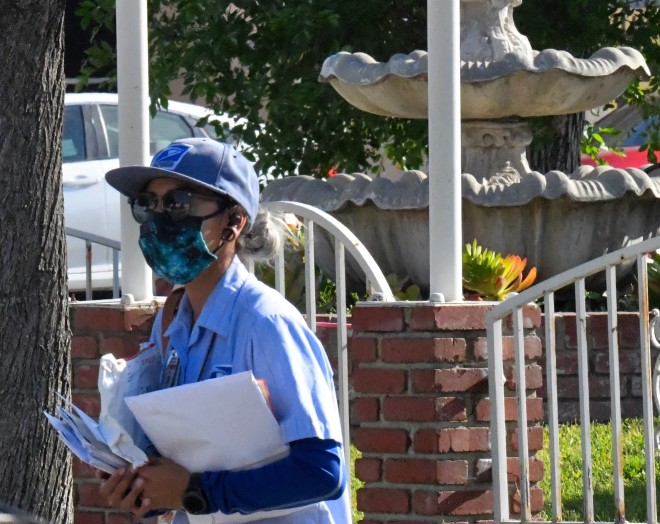 mailman with postal mail on his hands